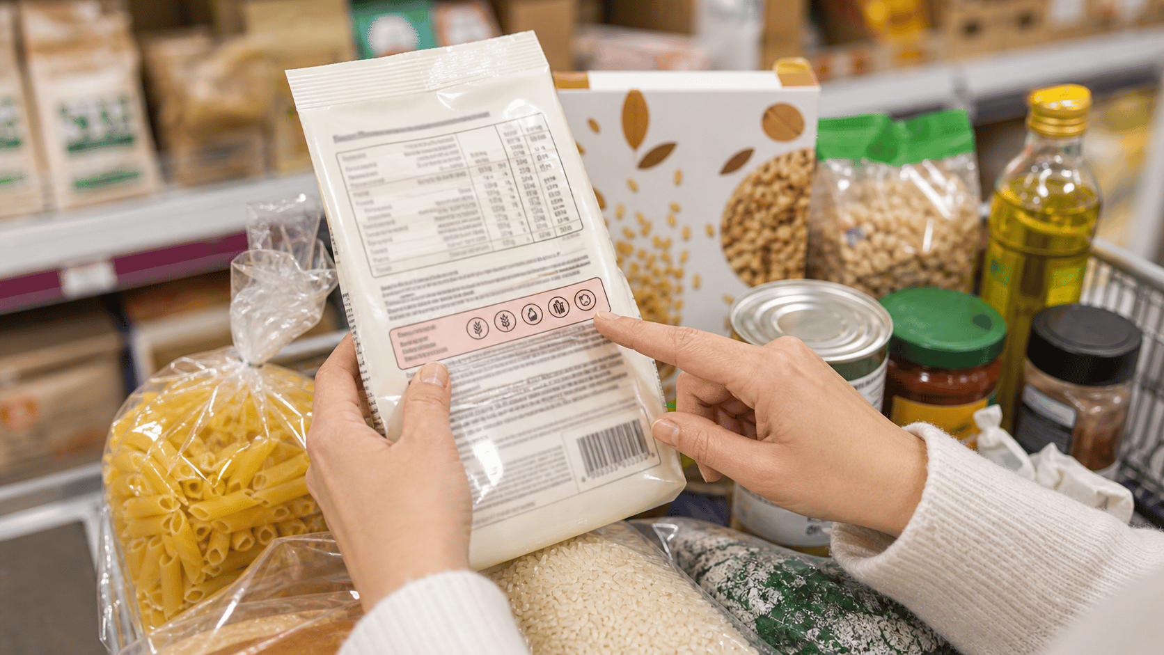 Packaged foods on a kitchen table with ingredient labels ready to be checked.